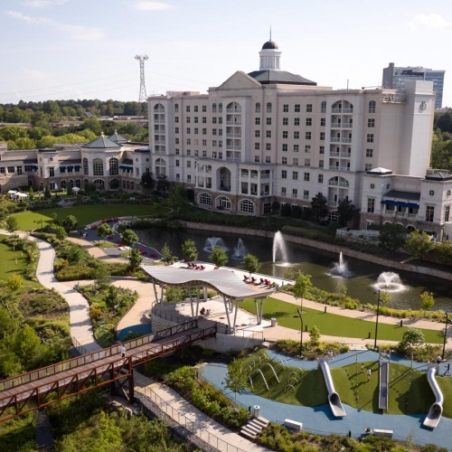 Relax and unwind poolside a large building with a pool in front of it