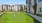 a building with a putting green, lawn and trees